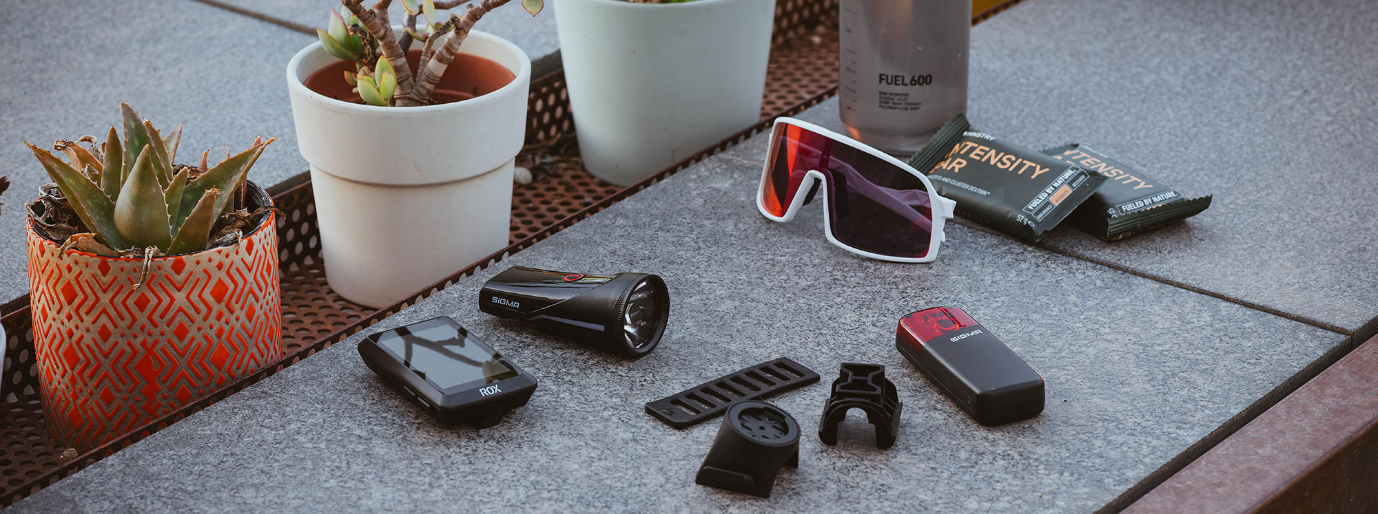 SIGMA RECO 81 LINK, ROX cycle computers and accessories arranged on a table.