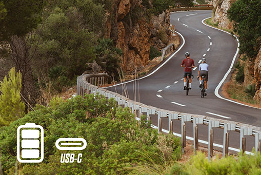 Two cyclists with SIGMA RECO 81 LINK lights on a winding coastal road.