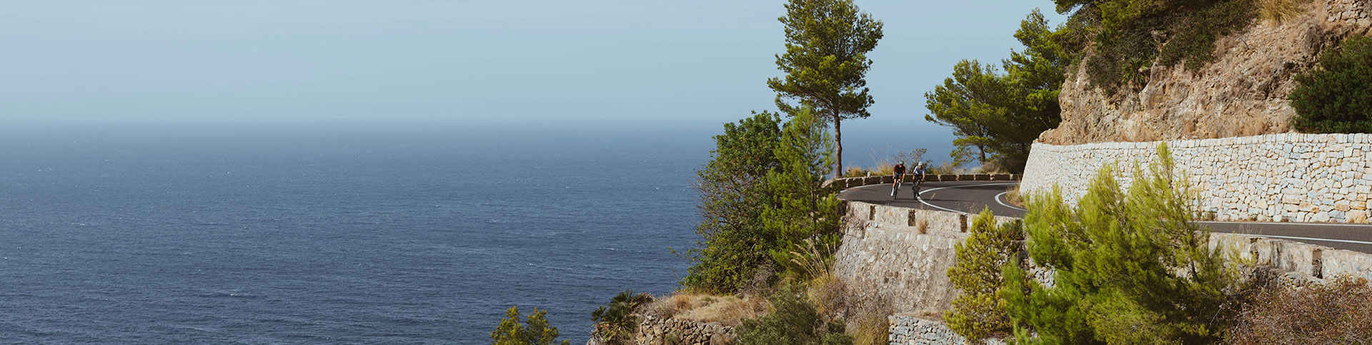 SIGMA RECO 81 LINK - Two cyclists on a winding coastal road.