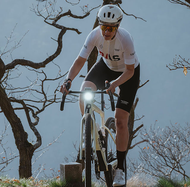 AURA 100 mounted on gravel bike while riding through forest