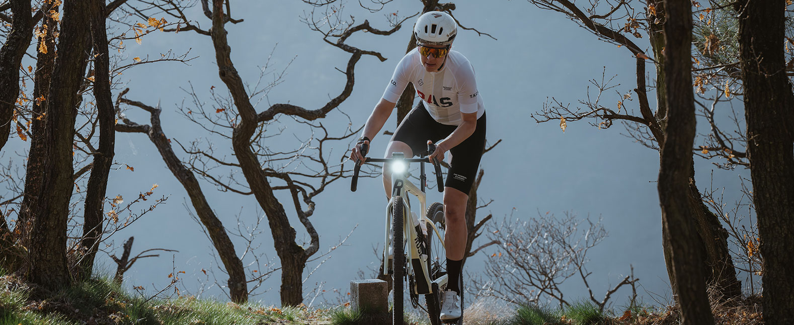 AURA 100 mounted on gravel bike while riding through forest
